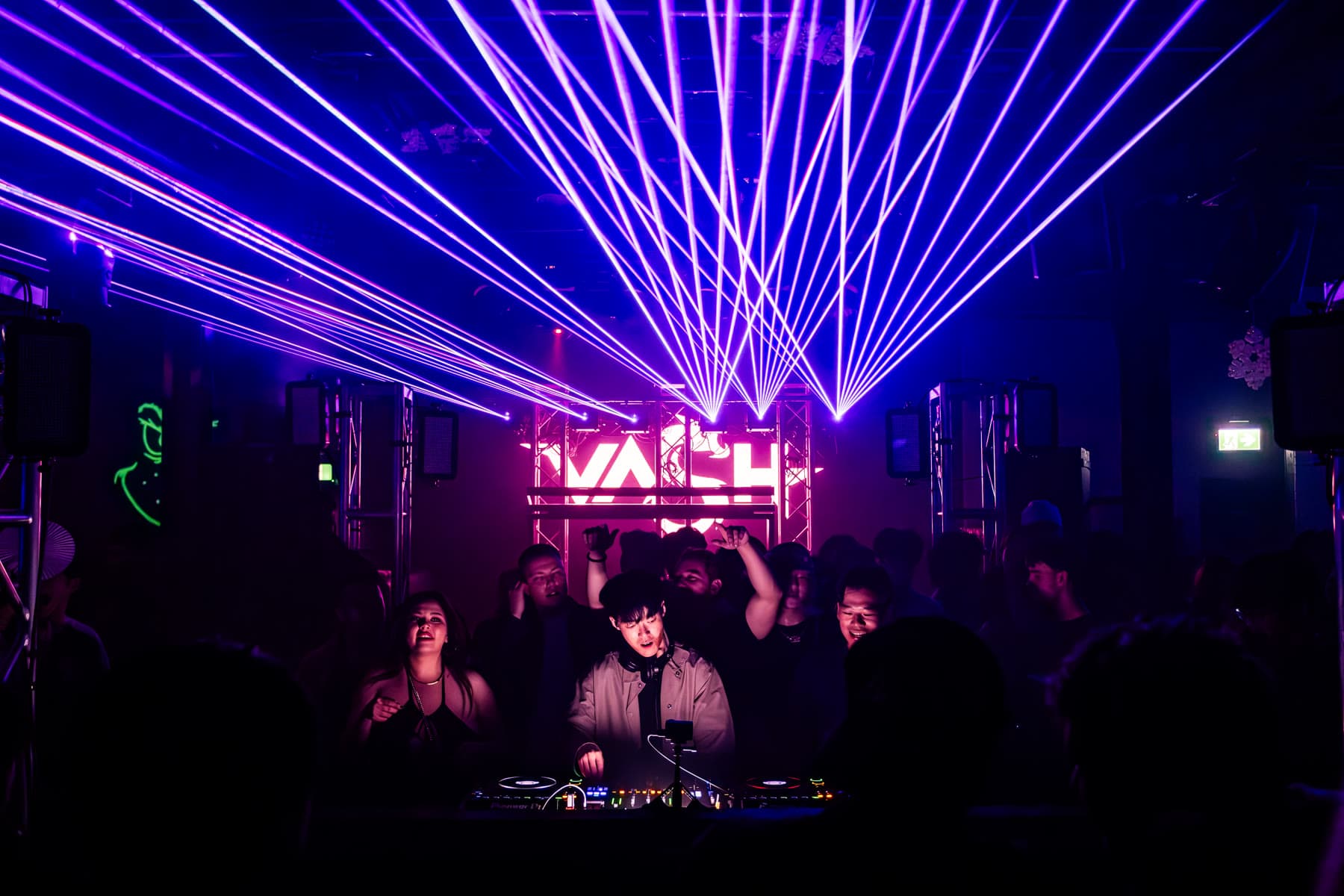 A wide fan of purple laser beams spread across a dark room